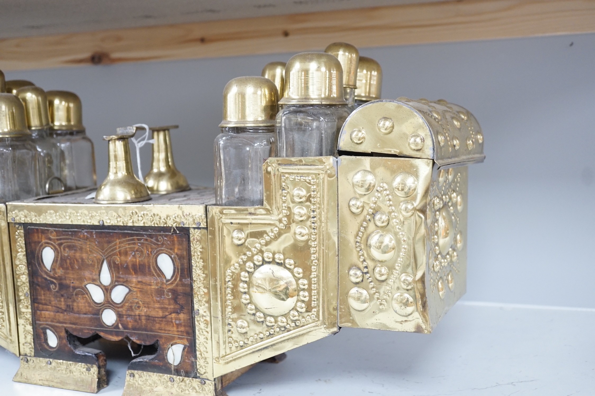 An Indian brass & hardwood shoe shiner's set, with twelve flasks. 57cm. long. 15cm. deep. 28cm. high